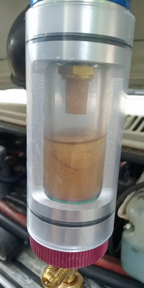 Brown contaminated refrigerant oil — proof of moisture damage