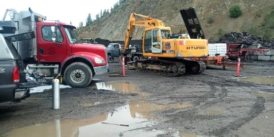Construction site with dump truck and Hyundai excavator — mobile A/C service in industrial environment